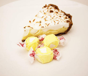 Lemon Meringue Taffy alongside a slice of lemon meringue pie, showcasing this salt water taffy flavor’s rich dessert inspiration.